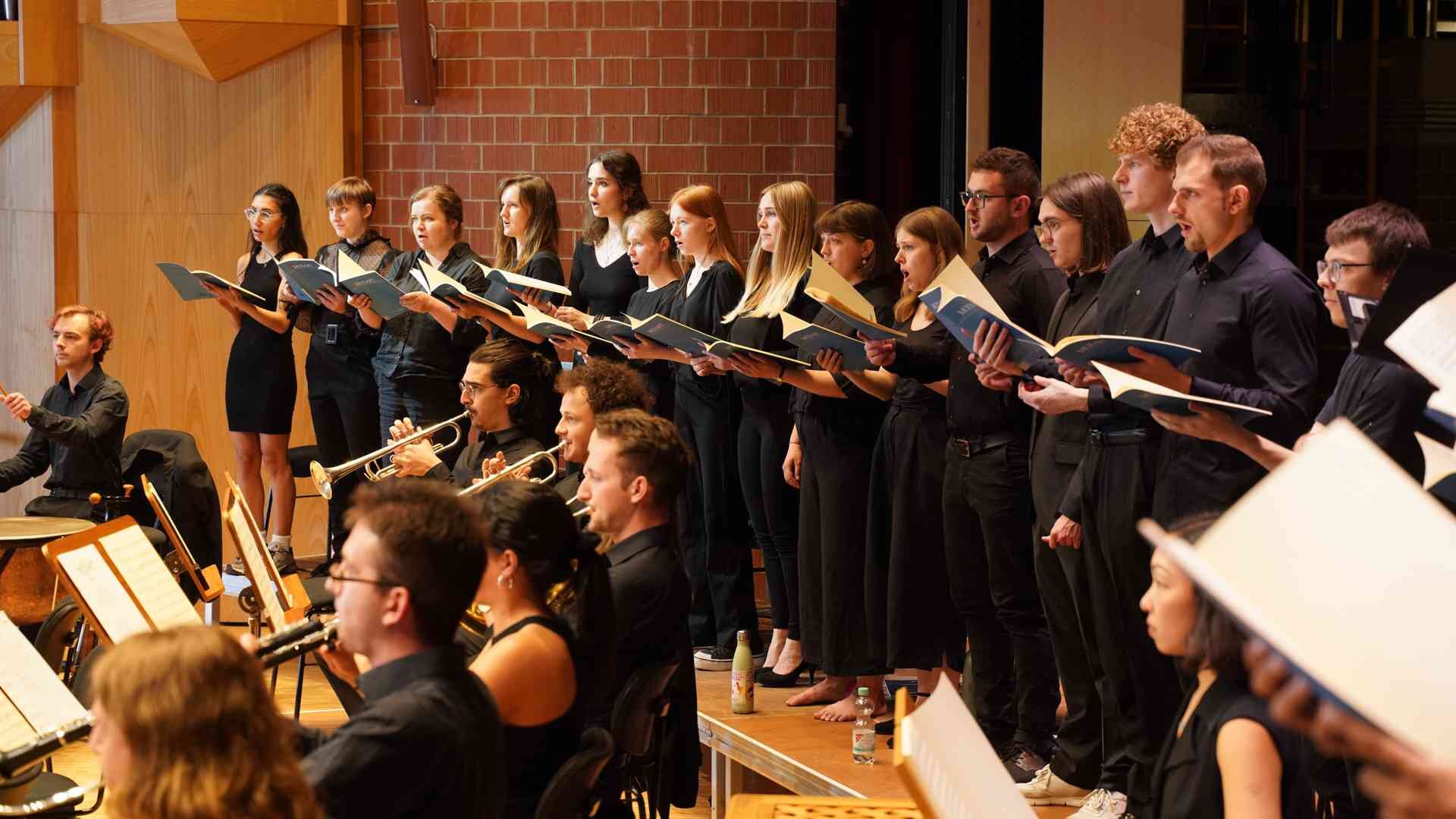 Gesangs-Studierende und Orchester bei einer Probe
